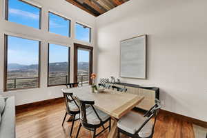 Dining space with a mountain view, hardwood / wood-style flooring, and a high wood ceiling