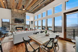 Dining room with hardwood / wood-style flooring, a fireplace, ceiling fan, and a high wooden ceiling