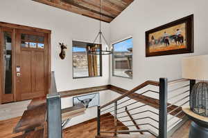 Stairs featuring hanging lights, wood finished floors, wood ceiling, and a mountain view
