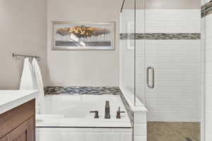 Bathroom featuring a bath, vanity, and a stall shower