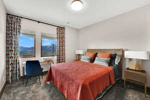 Carpeted bedroom featuring a desk and a mountain view