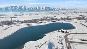 Snowy aerial view featuring a water and mountain view