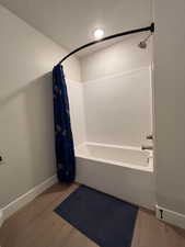 Full bath featuring light wood-type flooring and shower / bath combination with curtain
