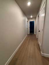 Corridor featuring baseboards and light wood-style floors