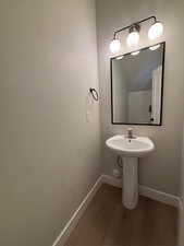 Bathroom with dark wood-style flooring and baseboards