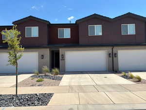 View of front of property with an attached garage, concrete driveway, and brick siding