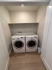 Laundry area featuring light wood finished floors and separate washer and dryer