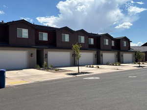 View of front of house featuring brick siding, driveway, and an attached garage