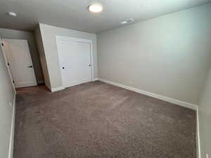 Unfurnished bedroom with a closet and dark colored carpet