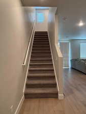Stairway with baseboards and hardwood / wood-style floors