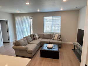 Living area featuring light wood-style floors and recessed lighting