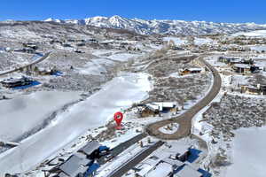 Snowy aerial view with a mountain view and a residential view