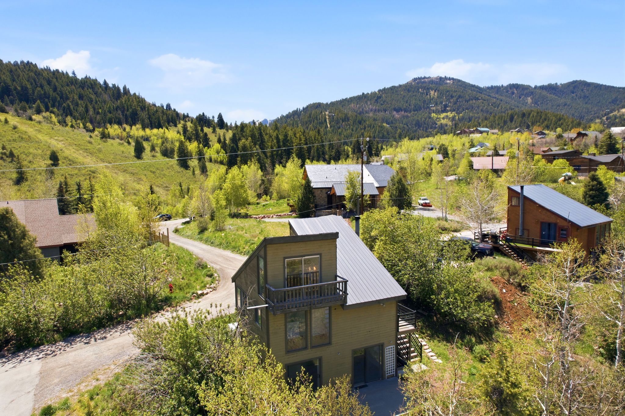 Modern mountain residence featuring a durable metal roof, multiple outdoor balconies, and large windows