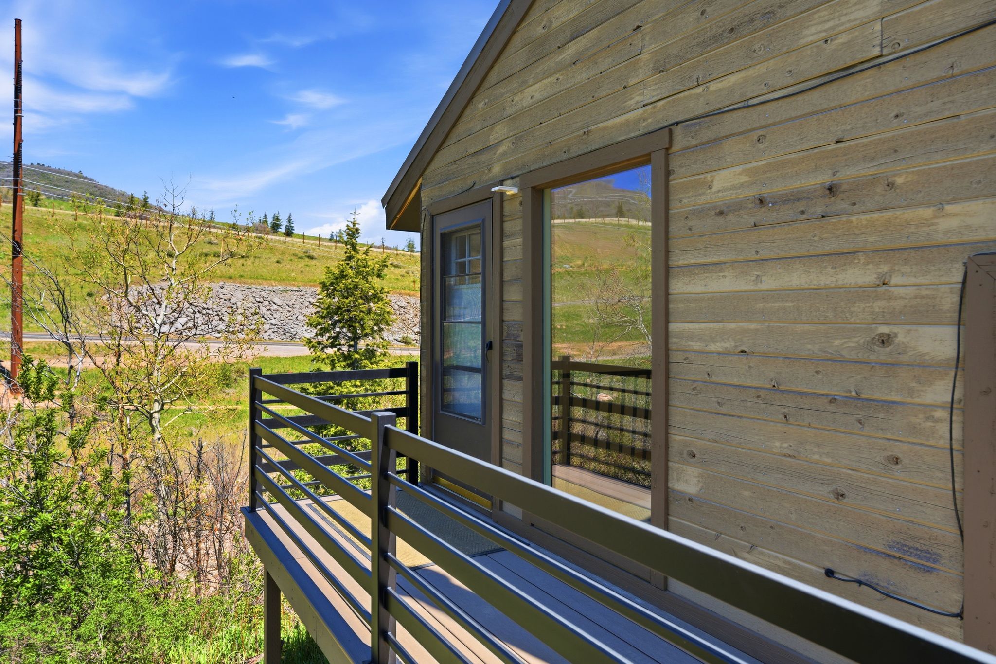 Exterior featuring horizontal wood siding, a full-lite exterior door, and a deck with dark-toned horizontal railings