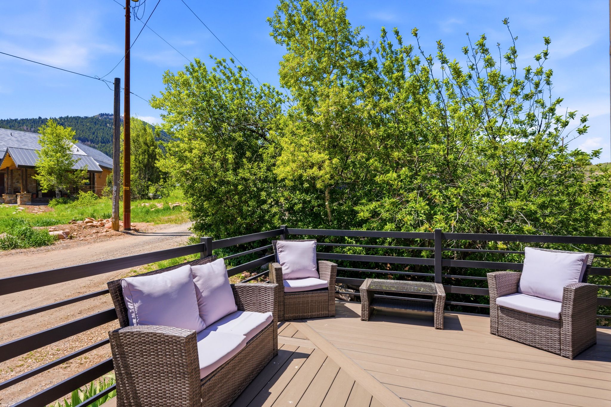 Expansive outdoor deck featuring wood-finish flooring and a dark horizontal railing