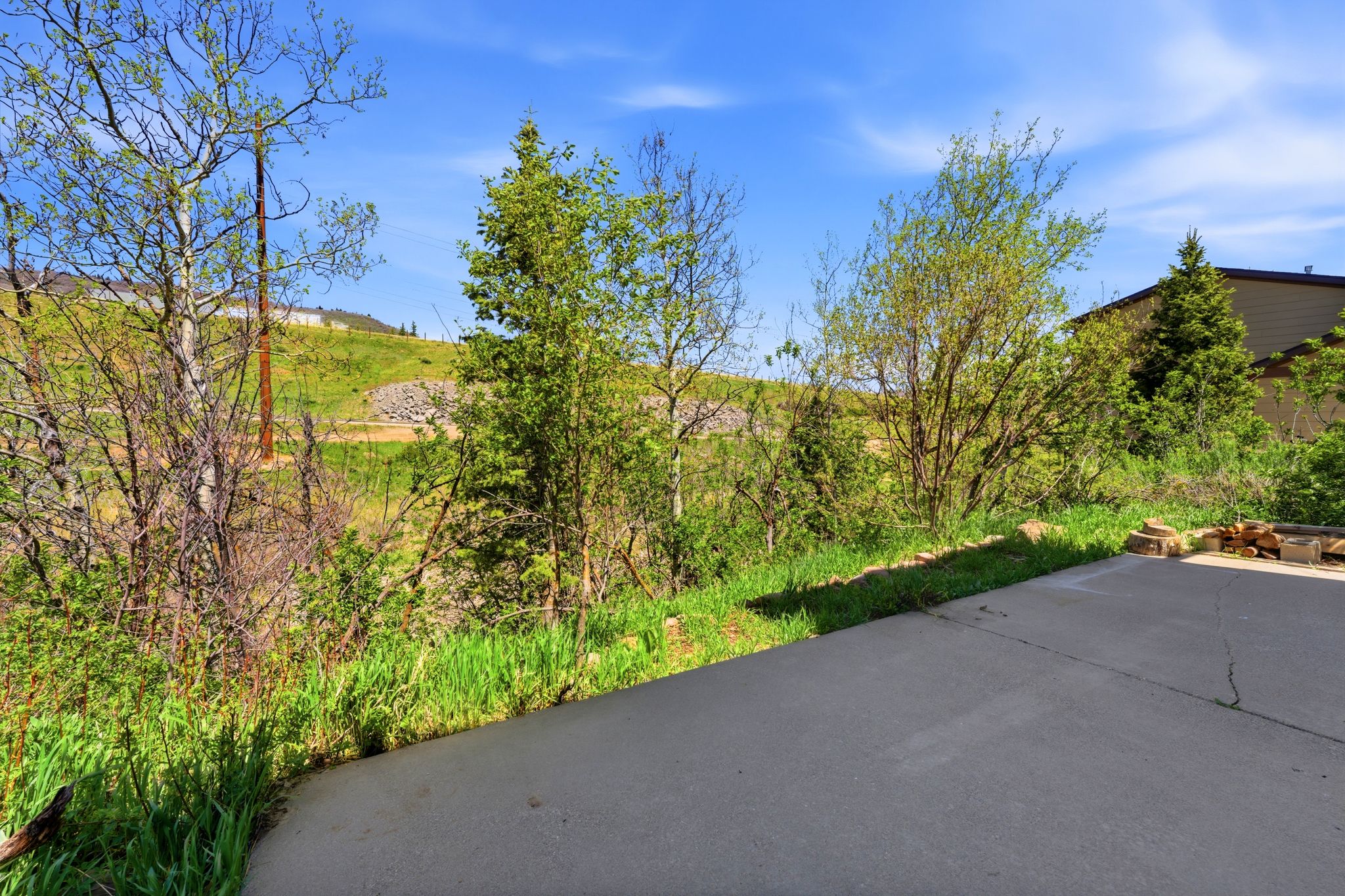 Paved outdoor area with surrounding natural landscaping and hillside topography