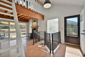 Stairway featuring a wood stove, wood finished floors, a high ceiling, and a mountain view
