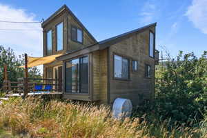 View of side of home featuring a wooden deck