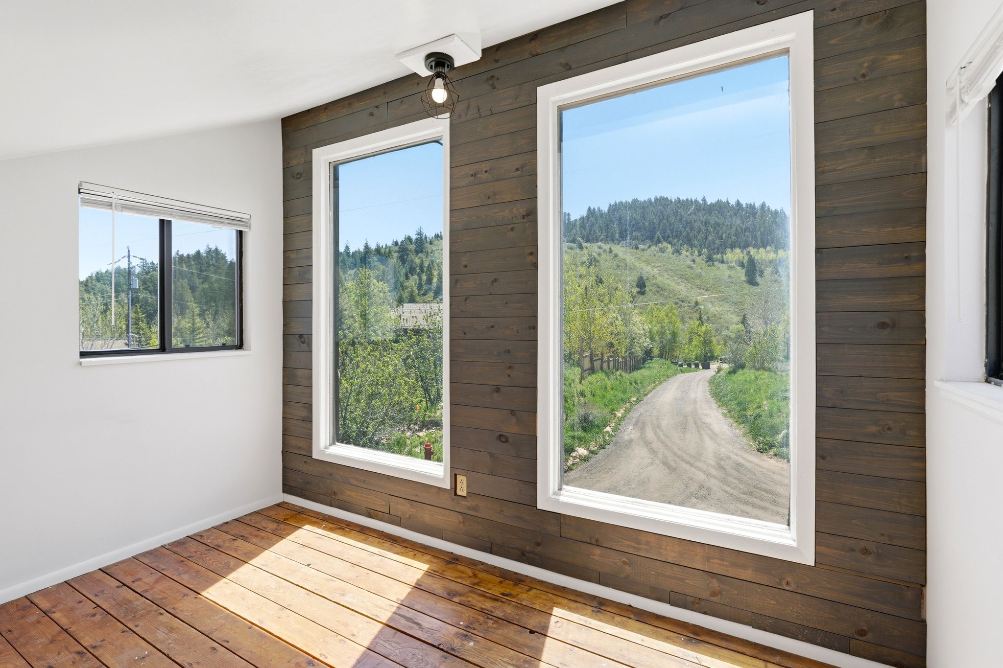 Room with wood-finish flooring and a wood-paneled accent wall