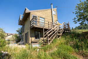 Back of property with a deck and stairs