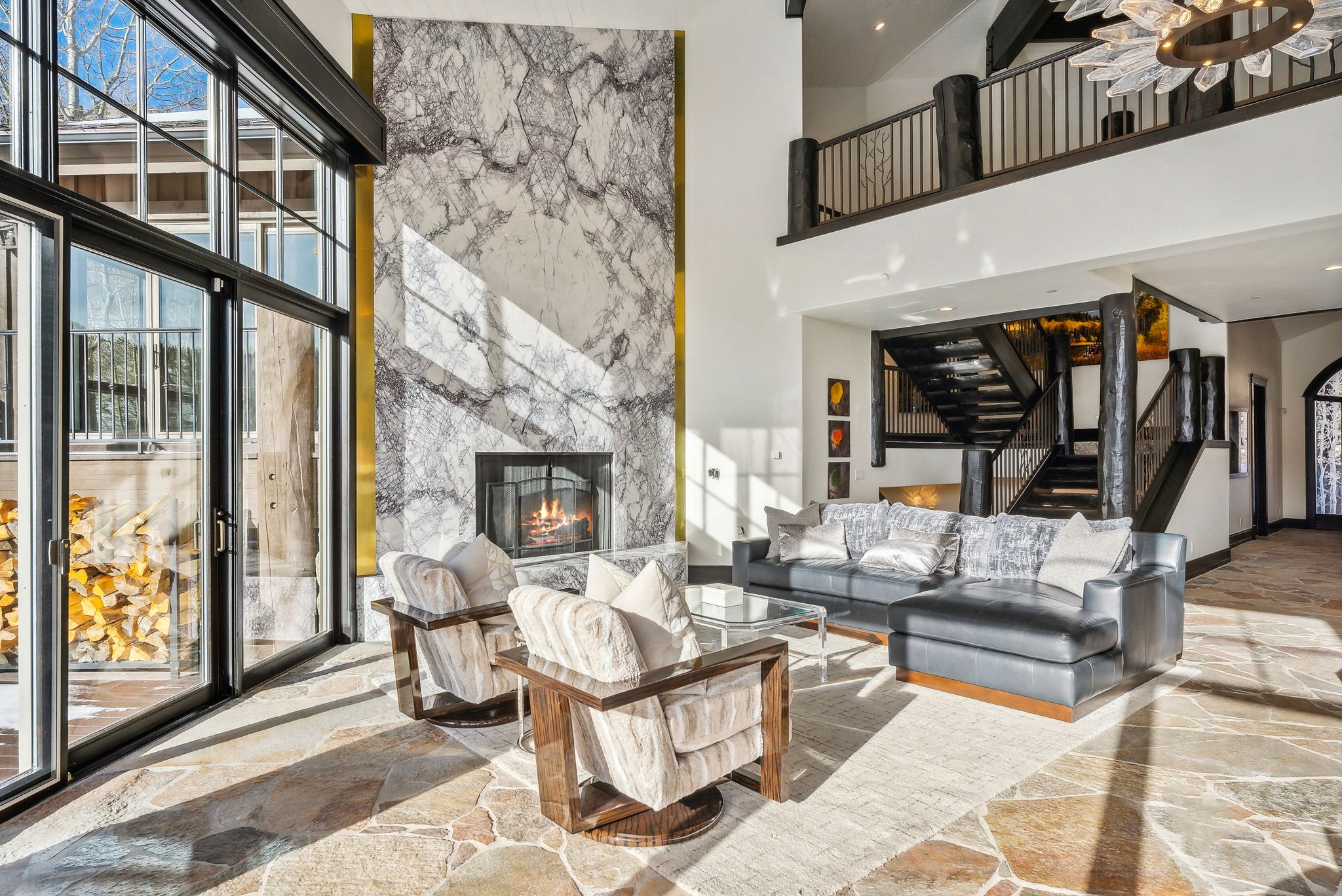 Living area with a fireplace, plenty of natural light, a high ceiling, and arched walkways