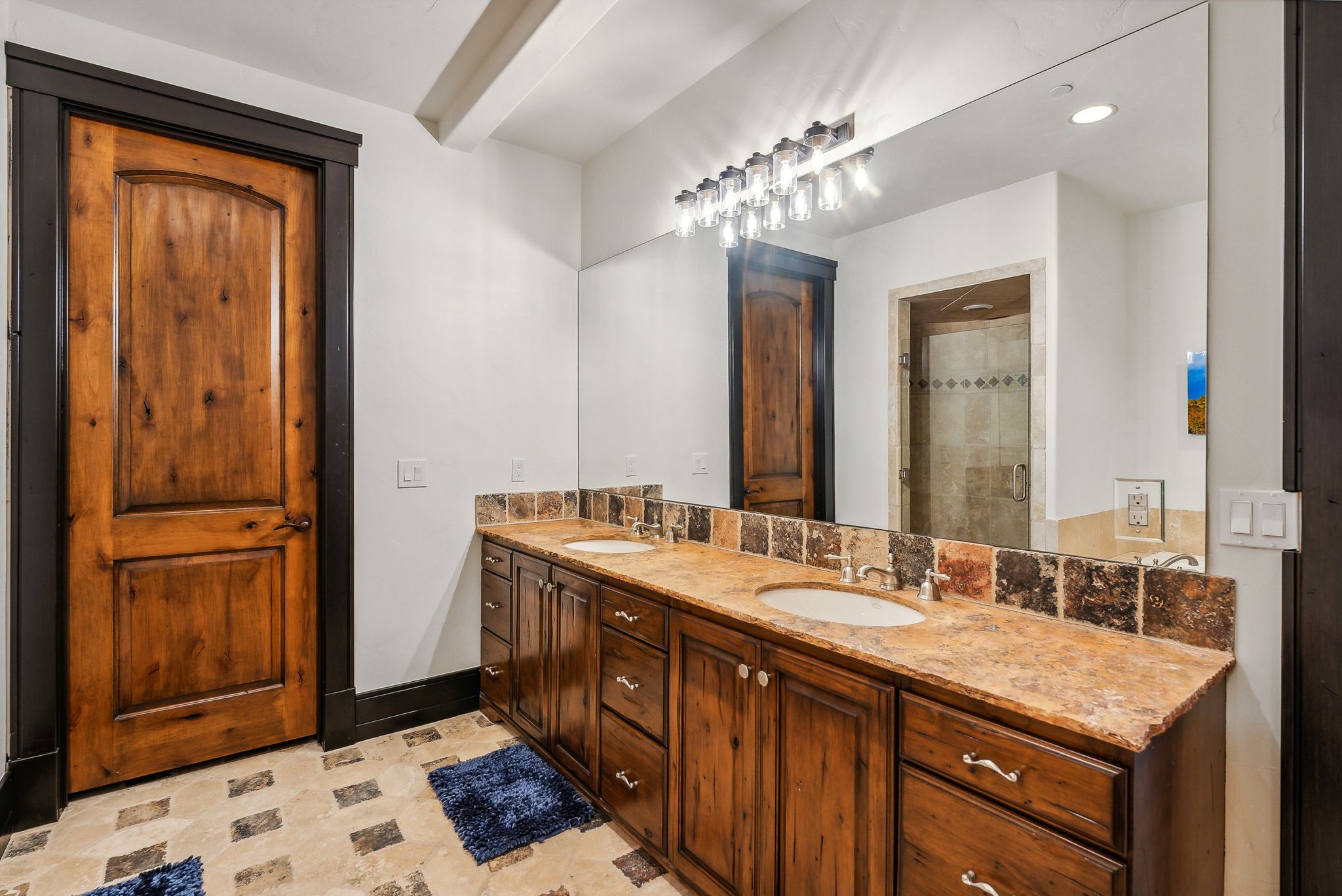Full bathroom with double vanity, a shower stall, and recessed lighting