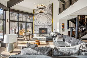 Living area with a fireplace, a chandelier, and a high wood ceiling
