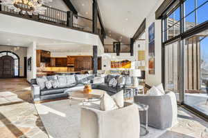 Living room with stone floors, recessed lighting, and a high ceiling