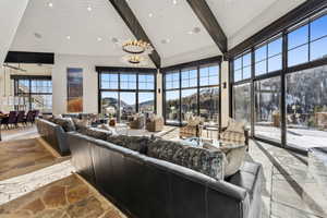 Living area with stone floors, suspended lighting, vaulted ceiling, and a mountain view