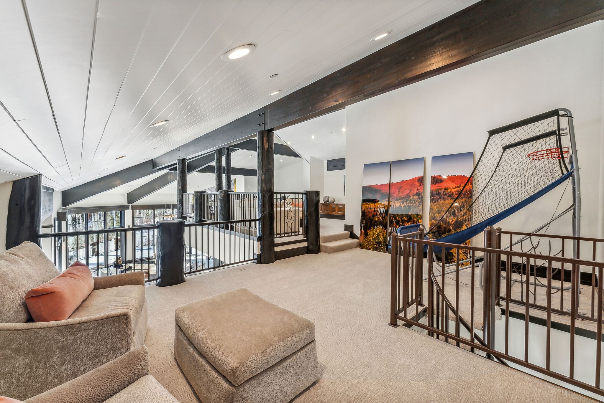 Sitting room with expansive windows, carpet flooring, an upstairs landing, recessed lighting, and beamed ceiling
