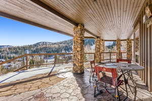 View of patio with a mountain view, outdoor dining area, and a forest view