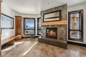 Unfurnished living room with a large fireplace and baseboards