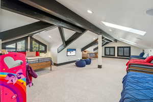 Bedroom featuring beamed ceiling, carpet floors, a skylight, and recessed lighting