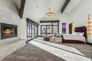 Carpeted bedroom featuring a stone fireplace, access to exterior, lofted ceiling, and recessed lighting