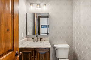 Half bath featuring vanity and tile walls