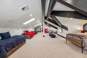 Bedroom featuring light carpet, a skylight, beamed ceiling, and recessed lighting