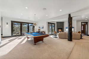 Recreation room featuring billiards table, a fireplace, recessed lighting, and light colored carpet