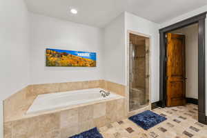 Full bath with a shower stall, a bath, and recessed lighting