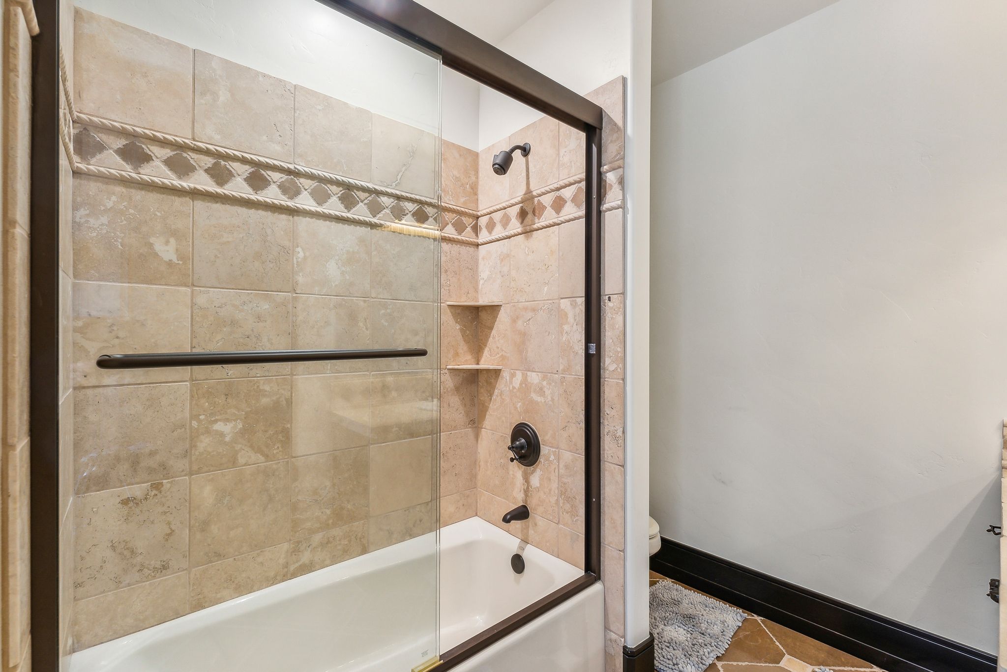 Bathroom featuring toilet and enclosed tub / shower combo