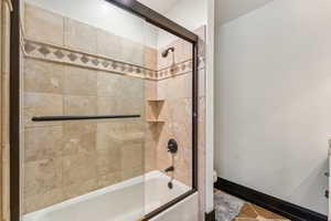 Bathroom featuring toilet and enclosed tub / shower combo