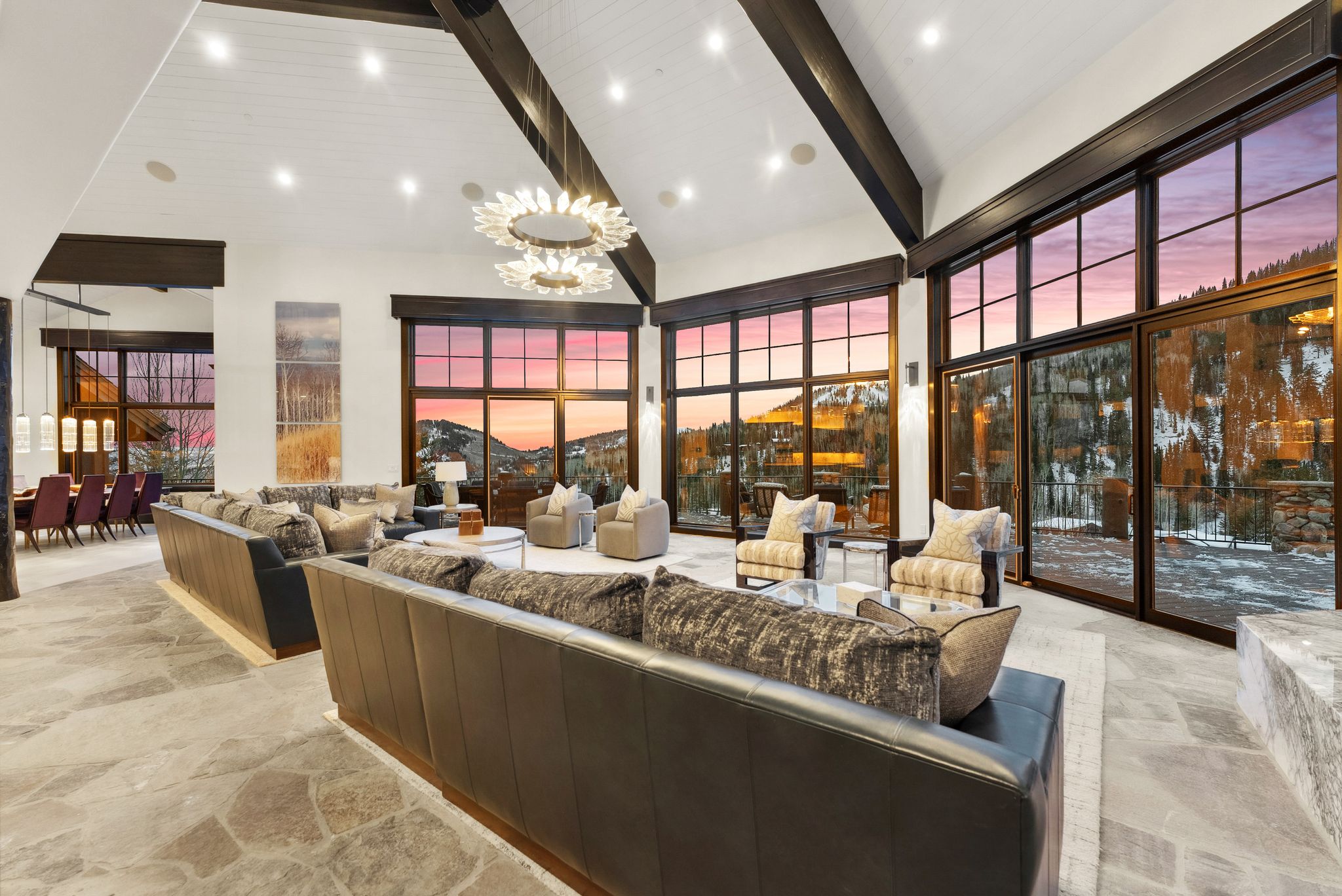 Living area featuring stone floors, suspended lighting, and vaulted ceiling