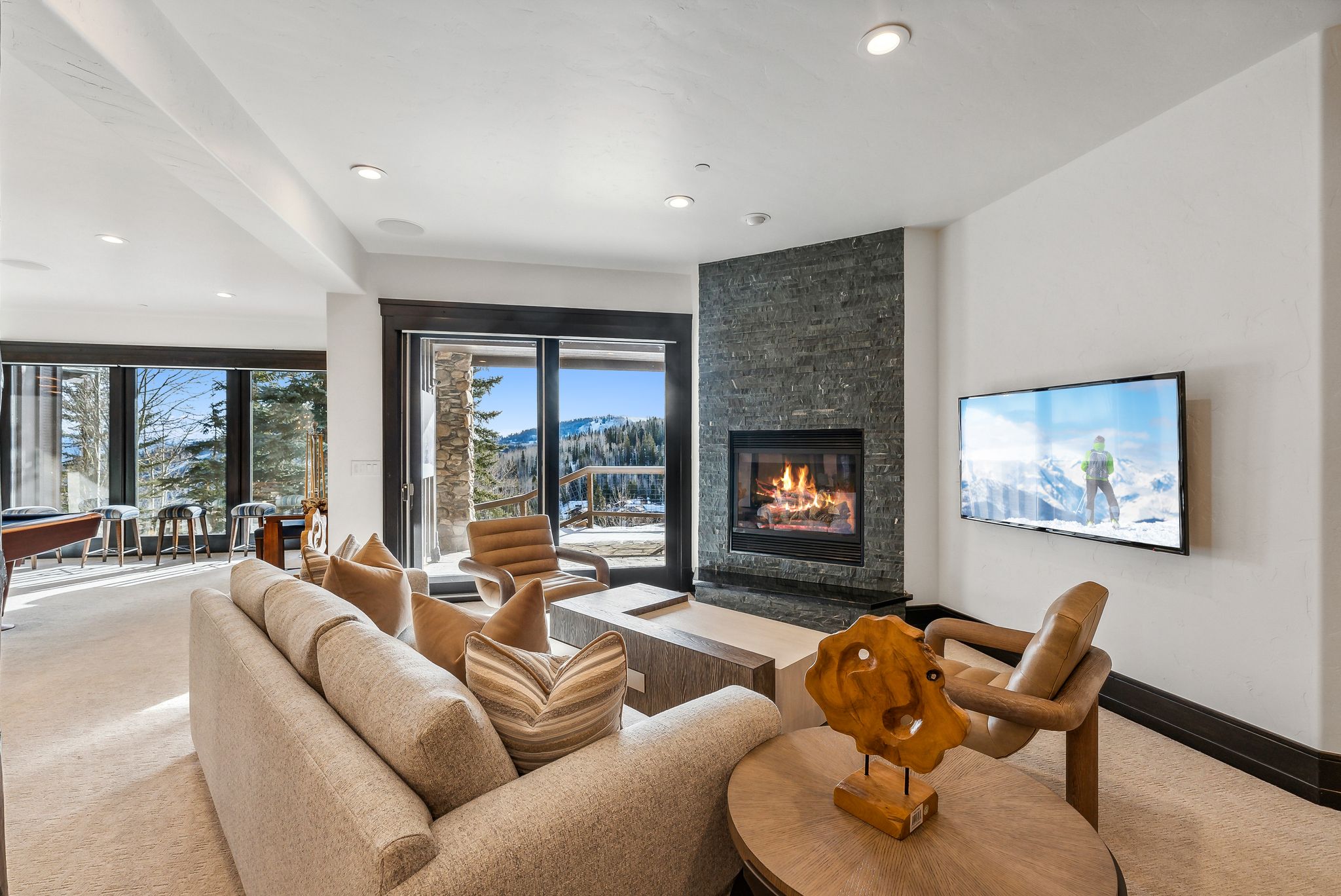 Living room featuring a stone fireplace, light carpet, pool table, and recessed lighting