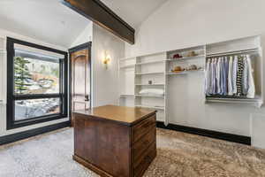 Walk in closet with lofted ceiling with beams