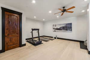 Workout area featuring light wood-type flooring, recessed lighting, and ceiling fan