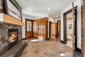 Entrance foyer featuring a glass covered fireplace and recessed lighting
