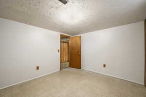 Empty room featuring tile patterned floors and a textured ceiling