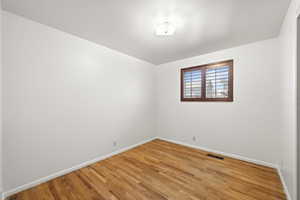 Empty room featuring baseboards and light wood finished floors