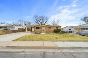 View of front of house featuring an attached carport, concrete driveway, and brick siding