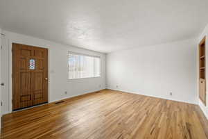 Entrance foyer featuring light wood finished floors and a textured ceiling