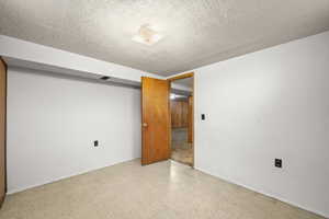 Spare room with tile patterned floors and a textured ceiling